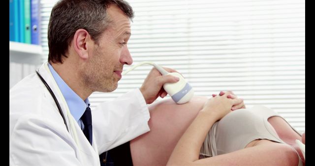 Doctor performing ultrasound on pregnant woman smiling - Download Free Stock Images Pikwizard.com