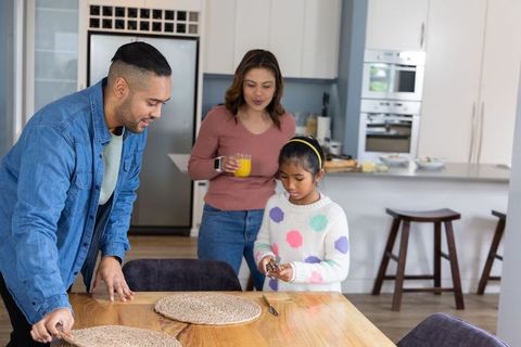 Indian family preparing breakfast together in bright modern kitchen parenting moment