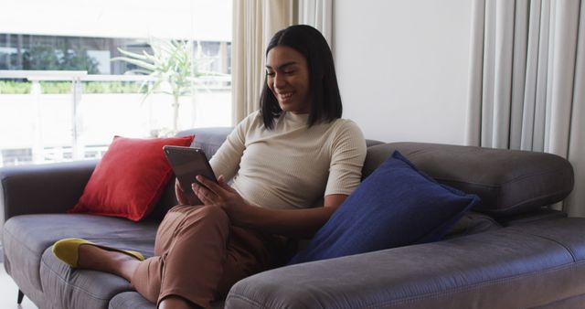 Woman Relaxing on Sofa Reading Tablet in Modern Living Room - Download Free Stock Images Pikwizard.com