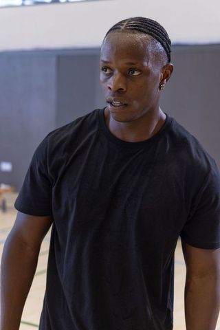 African american athlete standing on indoor court sweating and focusing during training