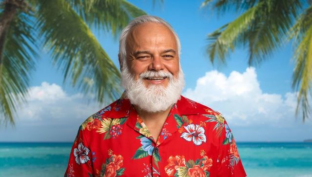 Smiling senior man in hawaiian shirt by turquoise sea