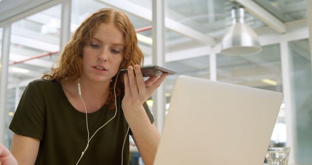 Young Woman Working at Laptop While on a Phone Call in Modern Office - Download Free Stock Images Pikwizard.com