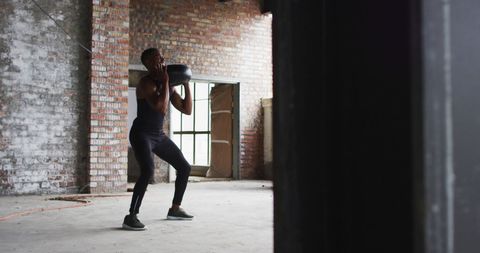 Fitness Enthusiast Exercises with Medicine Ball in Urban Loft