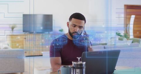 Man Engaging in Remote Work with Laptop and Smartphone at Home