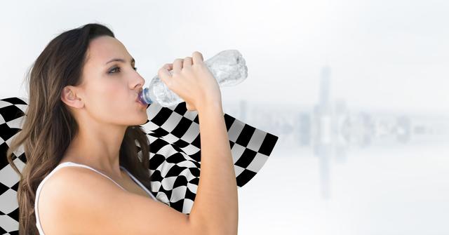 Digital composite of Female runner drinking against white skyline and checkered flag
