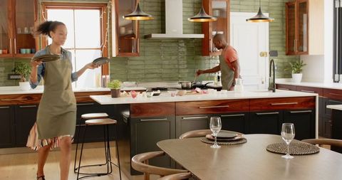 Couple cooking happily together in contemporary kitchen for meal preparation