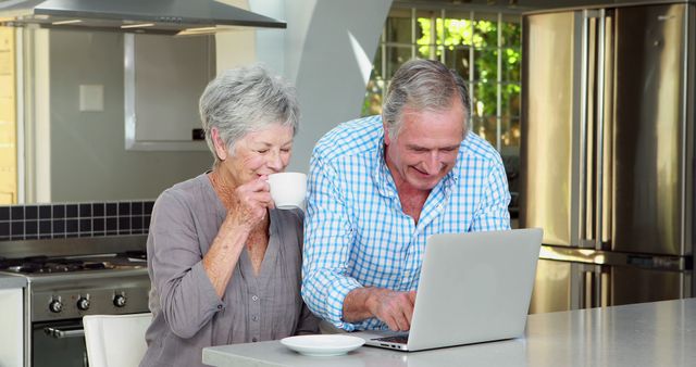 Senior couple using laptop in kitchen - Download Free Stock Photos Pikwizard.com