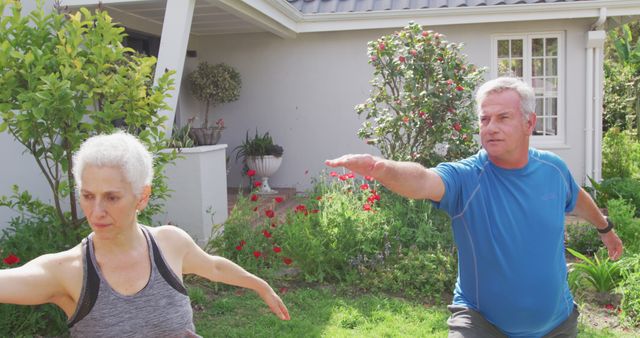 Senior couple practicing yoga poses in a backyard with garden plants. Great for use in articles or advertisements focused on elderly fitness, healthy living for seniors, outdoor exercise routines, wellness, and mindfulness practices.