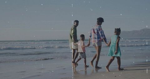 Multi-generational Family Walking on Serene Beach at Sunset