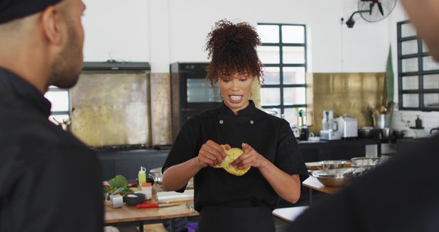 Chef is showing students how to prepare dough in a professional culinary class. Ideal for use in materials for cooking courses, culinary schools, food tutorials, and chef training programs. Can illustrate professional kitchen environments and instructional cooking methods.