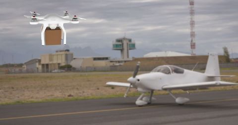 This image depicts a white drone carrying a brown box as it hovers in front of an aircraft on an airport runway. It highlights modern technology in delivering packages via air transport. Ideal for use in articles or content concerning advanced logistics solutions, digital innovation in delivery systems, or the future of cargo transport.