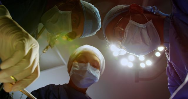 Surgeons Performing Operation in Dark Room with Surgical Lights - Download Free Stock Images Pikwizard.com