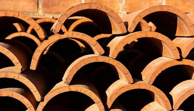 Sunlit Stacked Terracotta Roof Tiles Creating Repeating Arched Pattern and Warm Texture