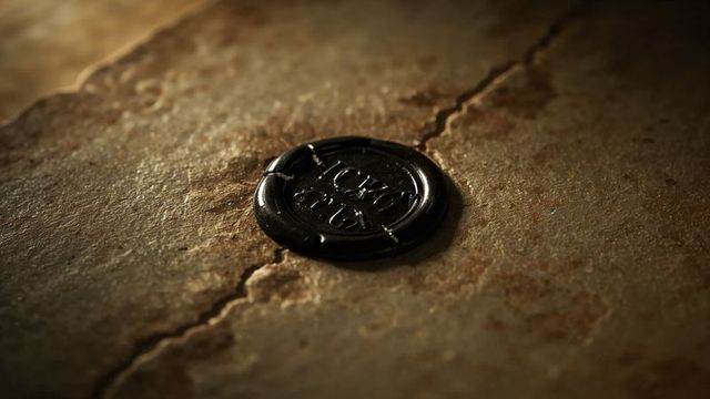 Close-up of embossed black wax seal on rustic surface