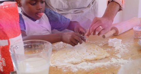 Father and son baking together shaping cookie dough