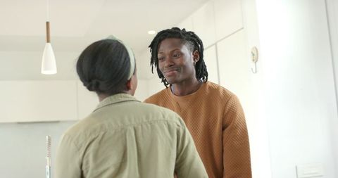 African american couple sharing warm conversation and smiling in modern minimalist kitchen