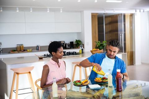 Couple Enjoying Fresh Homemade Burgers in Modern Kitchen