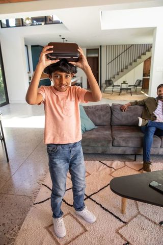 Father and Son Engaging in Virtual Reality in Modern Living Room