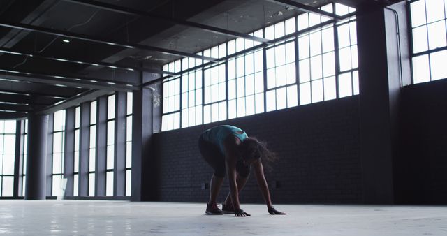 Woman Stretching in Spacious Industrial Room with Large Windows - Download Free Stock Images Pikwizard.com