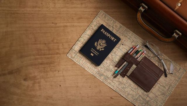 Us passport on vintage map with leather wallet and glasses for travel planning and packing