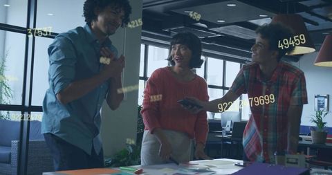 Young professionals collaborating and brainstorming around table in modern open office