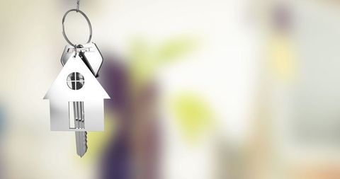 Silver House-Shaped Keychain with Keys Hanging in Home Entryway