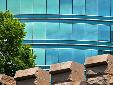 Modern glass building design with historical brick wall contrast
