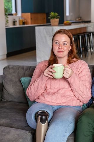 Smiling Woman Relaxing with Mug in Minimalist Living Room