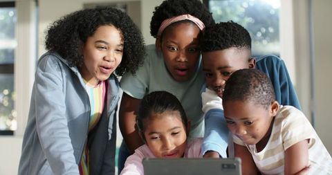 African American Multiracial Preteen Kids Gathering Around Tablet Collaborating and Learning