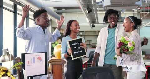 Diverse Team Celebrating Promotion with Smiles and Joyful Embrace