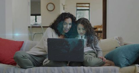 Mother and daughter sharing laptop on cozy couch, streaming, learning and bonding at home