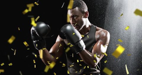 African american boxer celebrating victory with confetti