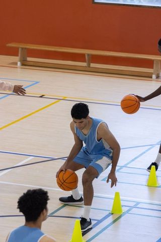 Teen Athletes Practicing Basketball Dribbling Drills Indoors