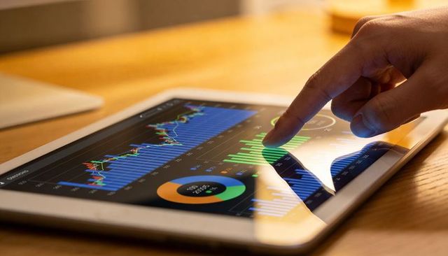 Interacting with financial dashboard on tablet showing charts, graphs, analytics trends