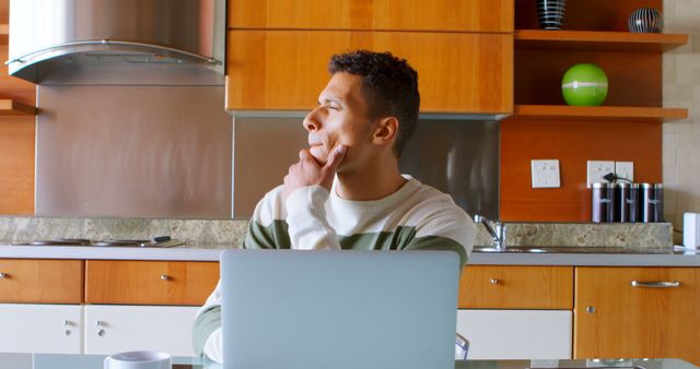 Man Thinking While Working on Laptop in Modern Kitchen - Download Free Stock Images Pikwizard.com