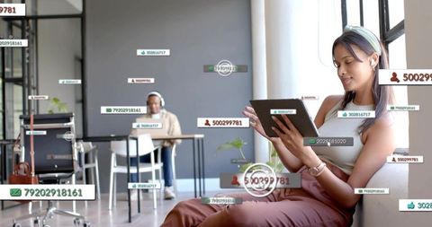 Young woman using tablet with augmented reality labels in sunlit coworking space for remote teams
