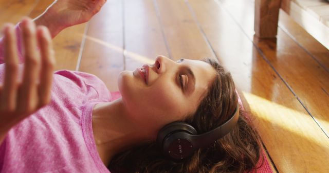 Young Woman Relaxing with Headphones on Wood Floor, Enjoying Music - Download Free Stock Images Pikwizard.com