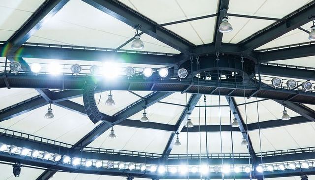 Highlighting central steel hub and radial beams with stadium floodlights and rigging
