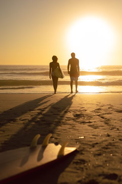 Couple walking together with surfboard on the beach - Download Free Stock Photos Pikwizard.com