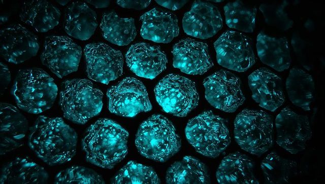 Glowing hexagonal crystal honeycomb revealing teal luminescent facets in macro pattern