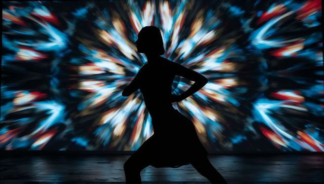 Silhouette of dancer with vibrant kaleidoscope projection