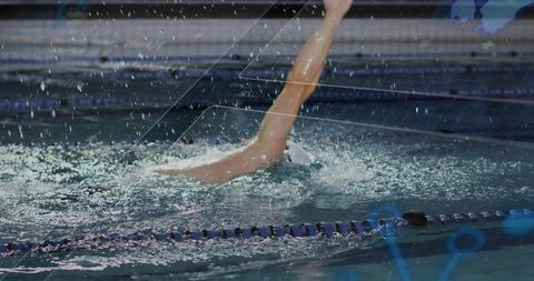 Athlete performing backstroke in training pool with splashing water