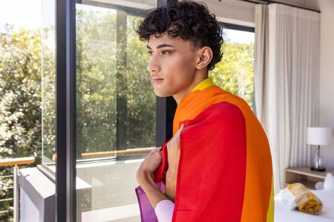 Confident person draped in rainbow flag embracing lgbtq+ identity