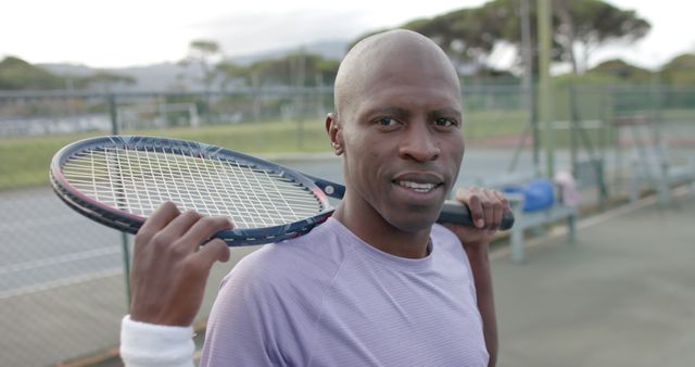 Confident African American Male Tennis Player Holding Racket on Court - Download Free Stock Images Pikwizard.com