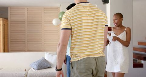 Woman Preparing Living Room with Balloons for a Festive Celebration