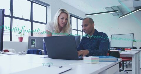Colleagues Collaborating Over Laptop in Modern Office Workspace
