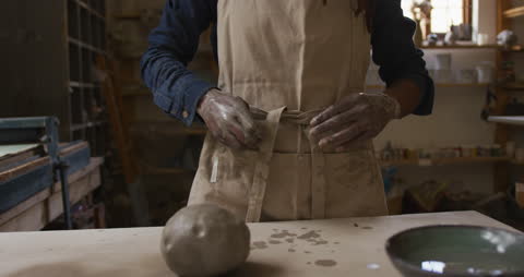Potter Securing Apron In Art Studio Setting