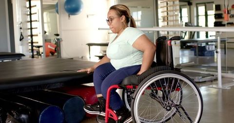 Woman in Wheelchair Engaged in Physiotherapy Exercises for Recovery