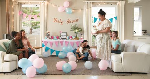 Joyful Friends Celebrating Baby Shower with Balloons and Gifts