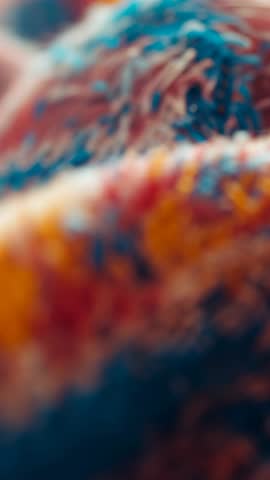 Vertical macro video of tufted yarn revealing vibrant fiber texture, soft pile motion